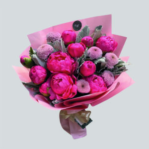 Ramo de peonías fucsias y pompones rosa malva con envoltorio rosado, creación exclusiva de Exóticas Flores en Santiago. Ideal para regalar o decorar con elegancia y frescura.