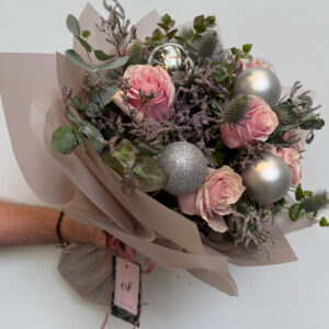 Ramo navideño elegante con rosas rosa pastel, eryngium, limonium y esferas plateadas, diseñado por Exóticas Flores.